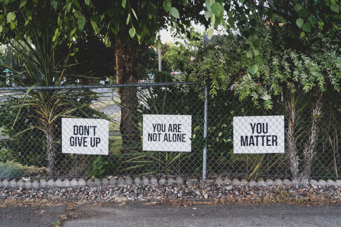 three-signs-with-words-of-support-on-a-fence