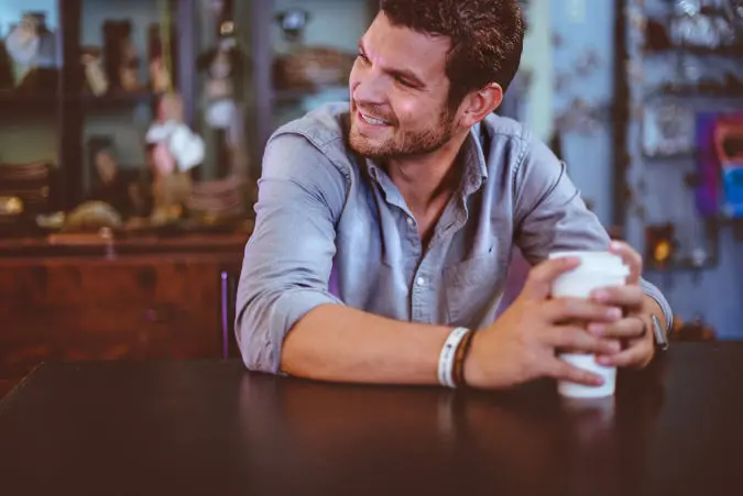 a-man-smiling-with-a-hot-drink